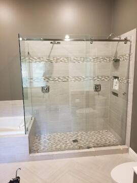 Frameless sliding glass shower enclosure with barn door track installed by Great Lakes Glass in Cleveland, Ohio